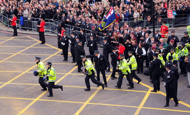 LONDON, ENGLAND - APRIL 17:  Police react before the cortege passes along Fleet Street towards St Paul's Cathedral on April 17, 2013 in London, England. Dignitaries from around the world today join Queen Elizabeth II and Prince Philip, Duke of Edinburgh as the United Kingdom pays tribute to former Prime Minster Baroness Thatcher during a Ceremonial funeral with military honours at St Paul's Cathedral. Lady Thatcher, who died last week, was the first British female Prime Minister and served from 1979 to 1990.  (Photo by Michael Regan/Getty Images) *** Local Caption ***  166796542.jpg