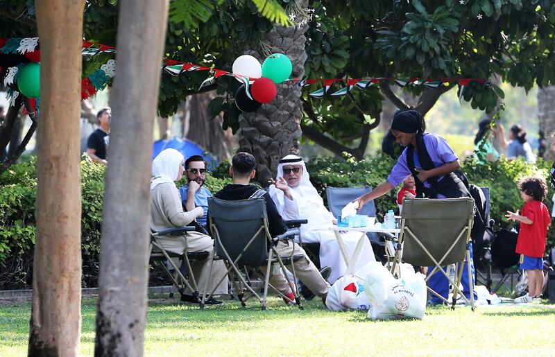 Residents take a picnic beneath decorations in the colours of the UAE flag at Zabeel Park. Pawan Singh / The National