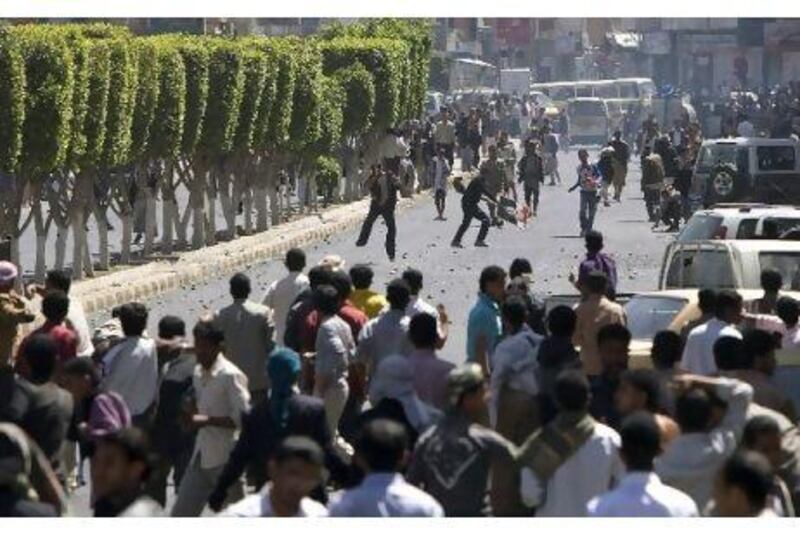 Yemeni regime loyalists (back) throw stones towards anti-government protesters during clashes in Sanaa on February 19. One protester was shot dead and five wounded in clashes with Yemeni government supporters near the capital Sanaa's university campus.