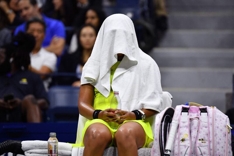 Japan's Naomi Osaka sits with a towel over her head during a break in her match against Canada's Leylah Fernandez.  AFP