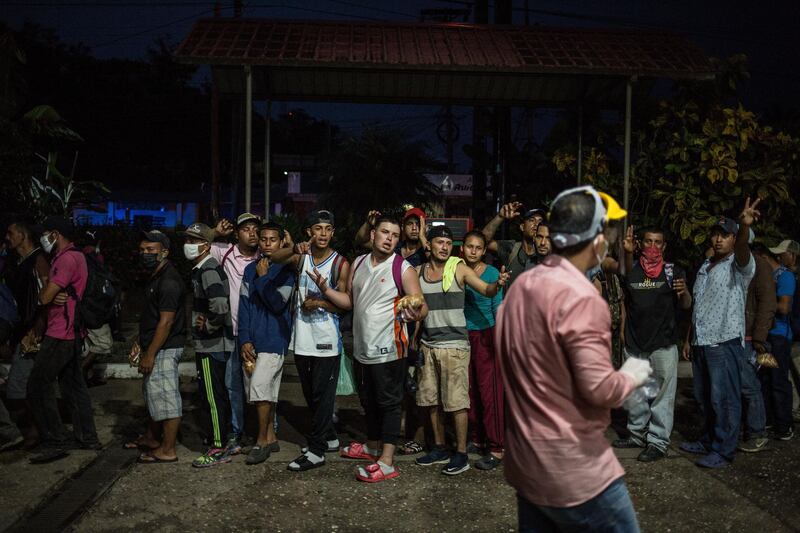 Honduran migrants wait to receive food from volunteers of the Esquipulas migrant shelter in Morales, Guatemala. EPA