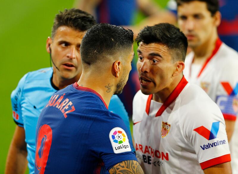 Atletico Madrid's Luis Suarez clashes with Sevilla's Marcos Acuna. Reuters