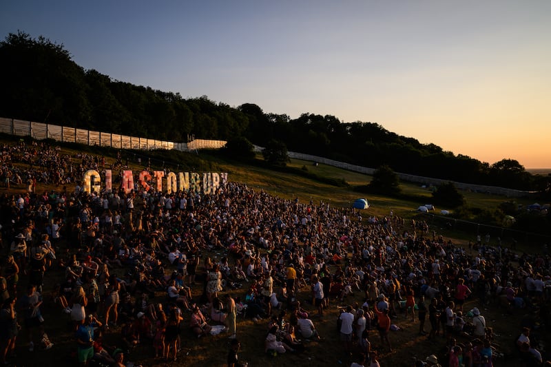 A 'Glastonbury' sign is illuminated by sunset on day one of the festival at Worthy Farm in Somerset. Getty Images