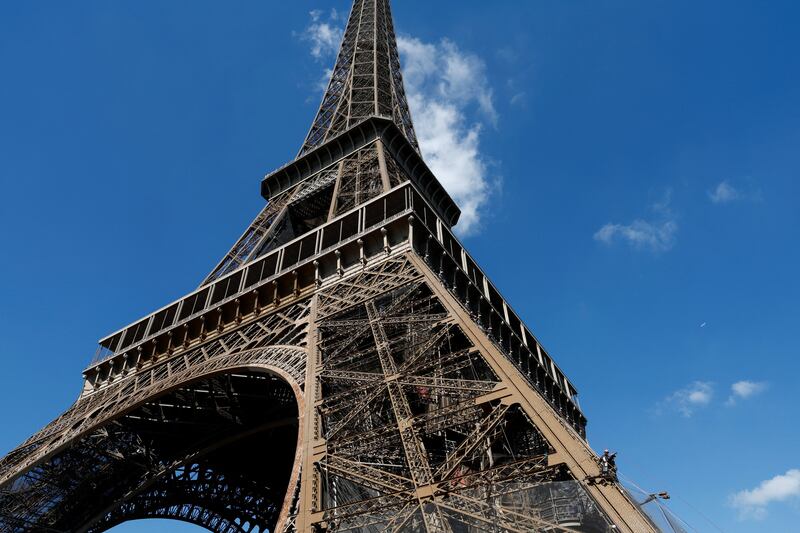 Workers strip the Eiffel tower for the 20th full repainting job during its 135-year history. Reuters