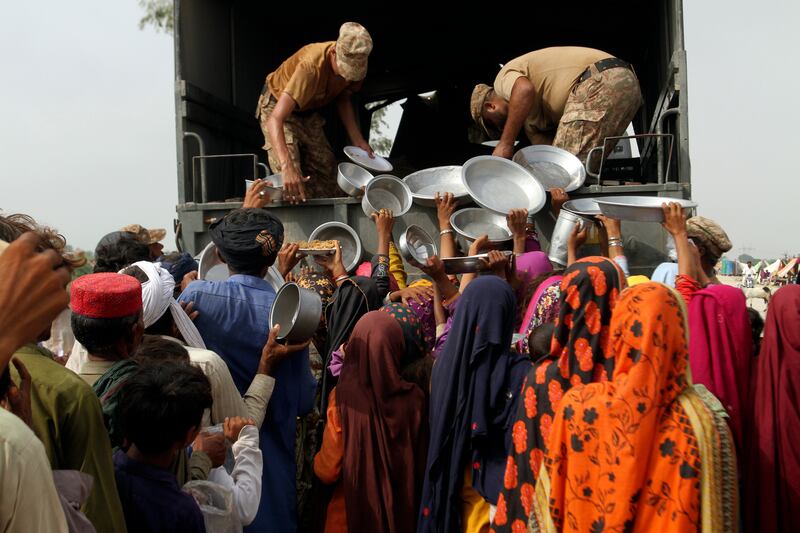Troops distribute food and other essentials to the displaced people of flood-hit Rajanpur district in Punjab. AP