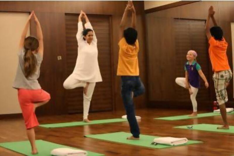 Deepali Dandekar, second from left, teaches yoga for children at Balance Wellness Centre in Dubai. "The lifestyle here means it is difficult to just go and run around outside and burn off energy," she says. Pawan Singh / The National