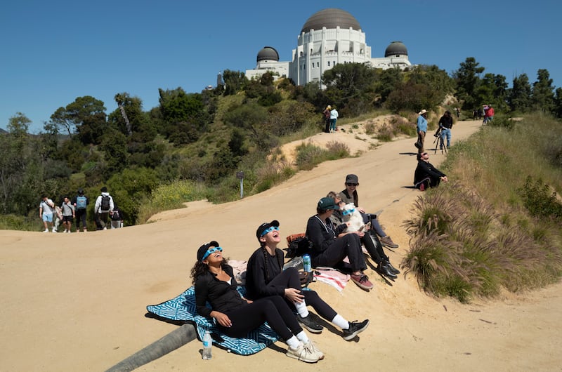 Spectators use special glasses to watch the solar eclipse near Griffith Observatory in Los Angeles. AP
