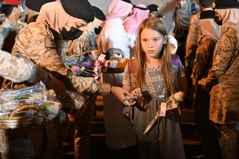 A young girl is greeted with food and gifts in Jeddah