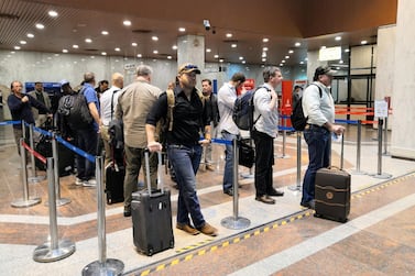 Foreign employees of oil companies queue at the airport in Basra on Friday. Reuters