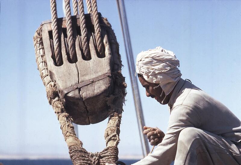 A sailor works with a boom’s great halyard block.