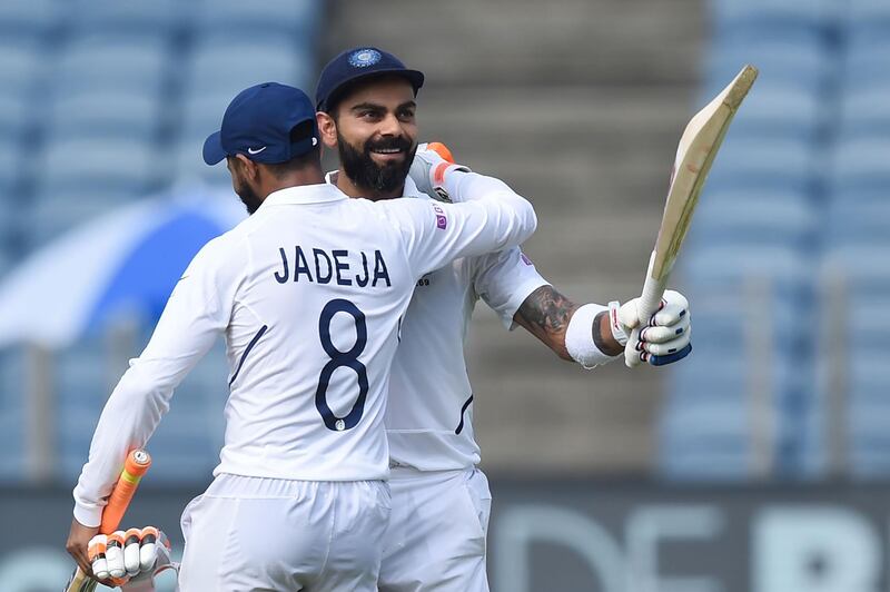 India's cricket team captain Virat Kohli (R) celebrates after scoring a double century (200 runs) as teammate Ravindra Jadeja congratulates him during the second day of the second Test cricket match between India and South Africa at Maharashtra Cricket Association Stadium in Pune on October 11, 2019. IMAGE RESTRICTED TO EDITORIAL USE - STRICTLY NO COMMERCIAL USE
 / AFP / PUNIT PARANJPE / IMAGE RESTRICTED TO EDITORIAL USE - STRICTLY NO COMMERCIAL USE
