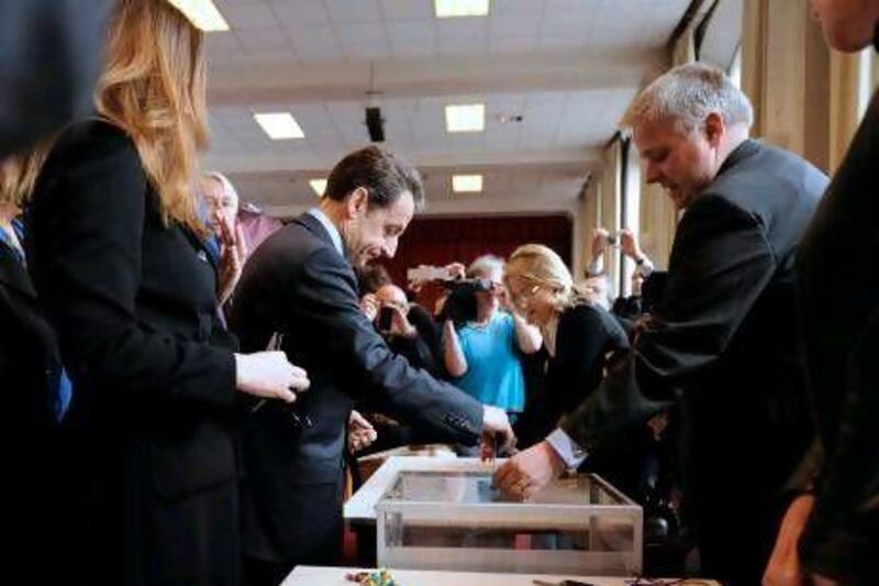 President Nicolas Sarkozy, second from left, casts his ballot in Paris yesterday in the first round of the French presidential election.