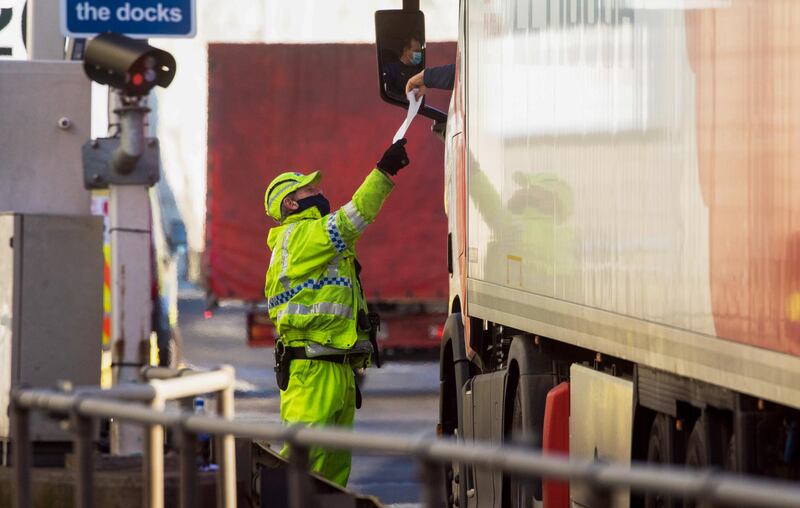 A policeman checks the paperwork of a truck driver. Bloomberg
