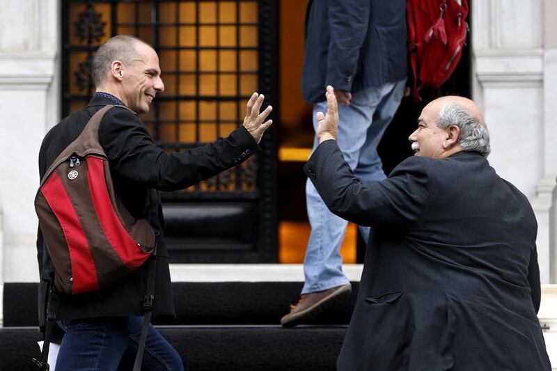 Yanis Varoufakis and interior minister Nikos Voutsis greet each other as they arrive at prime minister Alexis Tsipras' office at Maximos Mansion in Athens, Greece on June 28, 2015. Greek banks and the stock exchange will be shut on Monday after creditors refused to extend the country's bailout and savers queued to withdraw cash, taking Athens' standoff with the European Union and the International Monetary Fund to a dangerous new level. Marko Djurica / Reuters