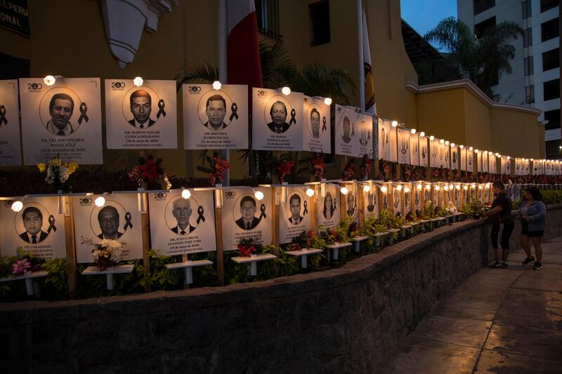 Relatives leave flowers on the portrait of Jorge Luis Casana, 62, a doctor who died due to the new coronavirus in Lima, Peru. AP