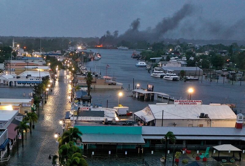 A fire is seen as floodwaters inundate the Tarpon Springs city centre after Hurricane Idalia passed offshore. AFP