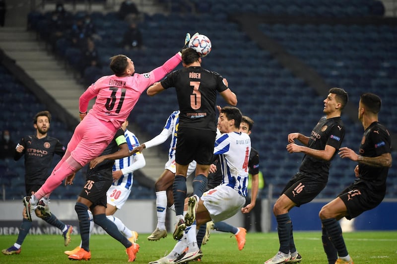 Manchester City's Brazilian goalkeeper Ederson (L) jumps to clear the ball during the UEFA Champions League group C football match between FC Porto and Manchester City at the Dragao stadium in Porto on December 1, 2020. (Photo by MIGUEL RIOPA / POOL / AFP)