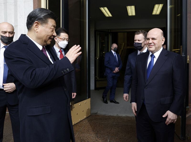 Mr Xi waves farewell to Mr Mishustin after the meeting in Moscow. Reuters
