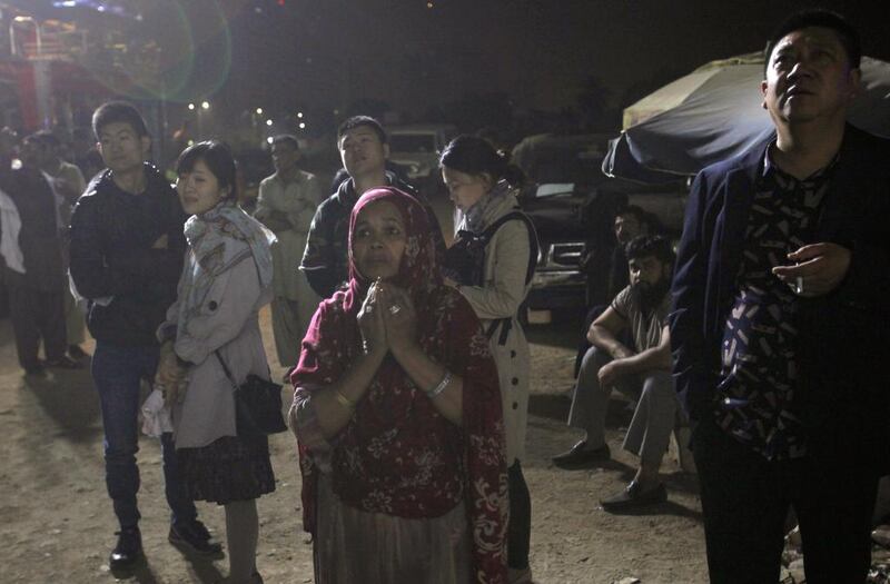 People stand outside the hotel in Karachi. Police senior superintendent Saqib Memon said the cause of the fire was not clear and an investigation had been launched. Shakil Adil / AP Photo