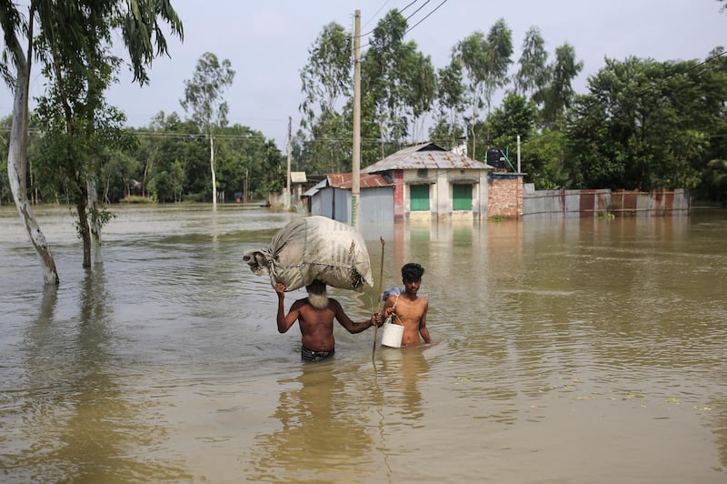 People move along a flooded area with their belongings in Gaibandha, Bangladesh, July 19, 2019. REUTERS/Rehman Asad NO RESALES. NO ARCHIVES