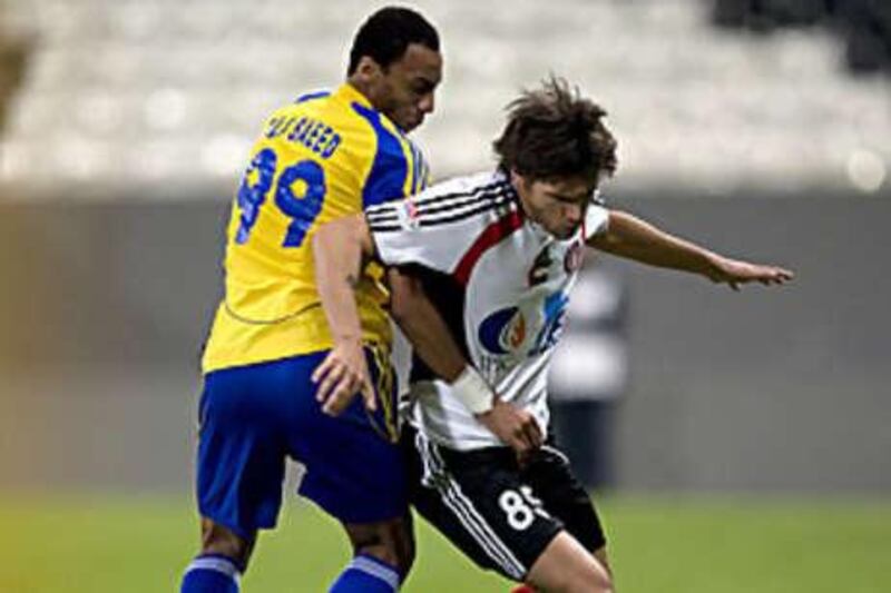 Al Jazira's Rafael Sobis, right, tussles with Al Dhafra's Ali Saeed during their league clash. Despite the win the Jazira boss Abel Braga was reportedly upset with the display.