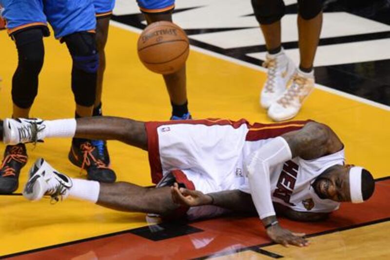 LeBron James of the Miami Heat takes a tumble during Game Four of the NBA Finals against the Oklahoma City Thunder on June 19, 2012 at the American Airlines Arena in Miami, Florida.   A hobbled LeBron James hit the go-ahead three pointer with 2:51 left in the fourth as the Miami Heat beat Oklahoma City Thunder 104-98 to move within one victory of their first NBA title since 2006.    AFP PHOTO / DON EMMERT


