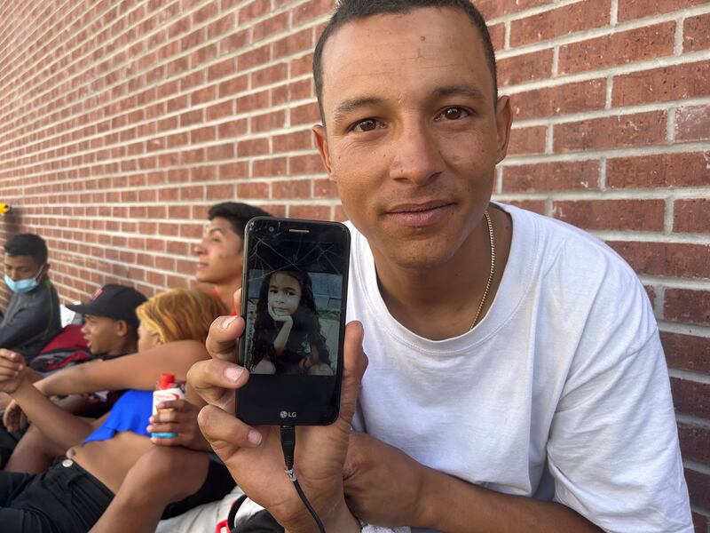 Dhean, 29, shows a picture of his daughter who is still in Venezuela