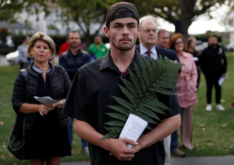 A man holds a fern, the national symbol of New Zealand, during a vigil for the victims of the mosque attacks. Reuters