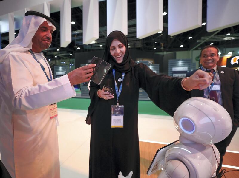 Abu Dhabi, UAE,  April 17, 2018.  
CITYSCAPE Abu Dhabi 2018.  Chafika Al Baloushi gets entertained by Pepper the robot at The Department of Urban Planning and Municipalities.
Victor Besa / The National
National
Reporter:  Sarah Townsend