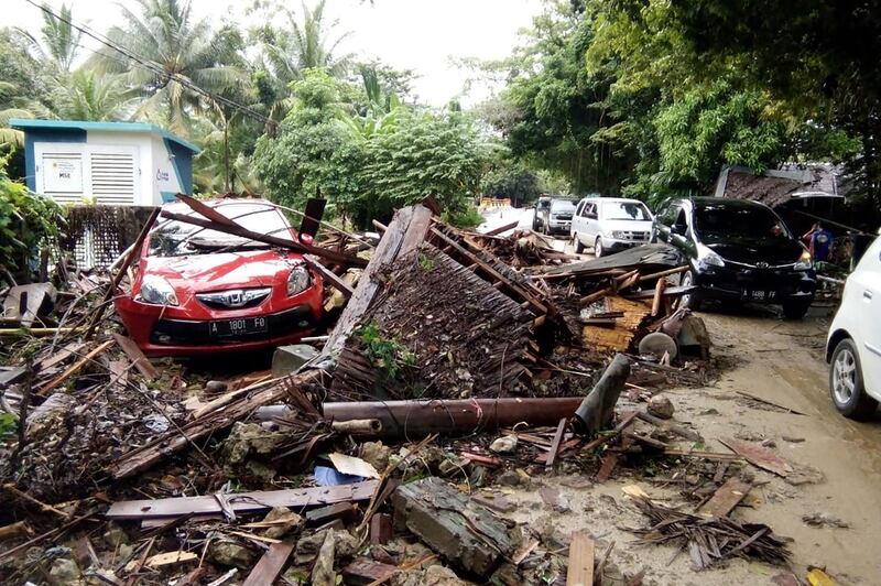 A damaged vehicle is seen amid wreckage from buildings along Carita beach. AFP