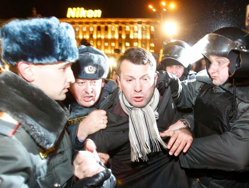 Policemen detain an activist during a rally to protest against the results of the parliamentary elections and the policies conducted by Russian authorities in Moscow December 6, 2011. Russians took to the streets of Moscow for the second successive day on Tuesday to demand an end to Prime Minister Vladimir Putin's 12-year rule, but riot police blocked their way and hundreds of pro-Kremlin youths tried to spoil the protest.  REUTERS/Mikhail Voskresensky  (RUSSIA - Tags: POLITICS ELECTIONS CIVIL UNREST CRIME LAW) *** Local Caption ***  MOS48_RUSSIA-ELECTI_1206_11.JPG