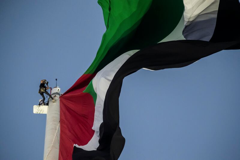 The National's Andy Scott climbs up the 123m flag pole with Trident Support on Sharjah's Flag island. Antonie Robertson / The National
