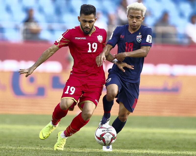 Dubai, United Arab Emirates - January 10, 2019: Komail Hasan Alaswad of Bahrain and Chanathip Songkrasin of Thailand battle during the game between Bahrain and Thailand in the Asian Cup 2019. Thursday, January 10th, 2019 at Al Maktoum Stadium, Abu Dhabi. Chris Whiteoak/The National