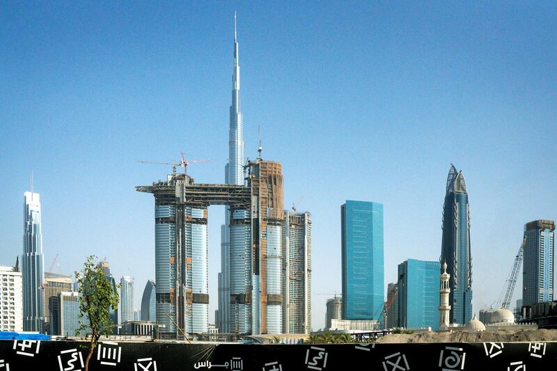 The Burj Khalifa skyscraper, center, stands on the city skyline beyond new skyscrapers under construction in Dubai, United Arab Emirates, on Tuesday, Sept. 12, 2017. Dubai residential property prices and rents are set to fall further as losses of high-paying jobs and dwindling household incomes boost vacancies across the city, according to Phidar Advisory. Photographer: Tasneem Alsultan/Bloomberg