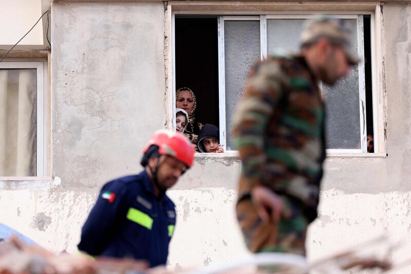 An Emirati rescuer, accompanied by a Syrian soldier, searches for survivors