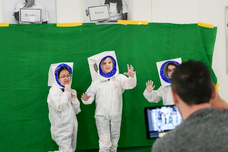 Junior pupils pose at a photo booth dressed in their astronaut costumes.