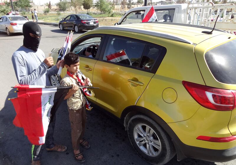 Iraqis handout their national flag in a street in the disputed norther Iraqi city of Kirkuk on October 19, 2017. 

Iraqi government forces said they had retaken almost all the areas disputed between Baghdad and the autonomous Kurdistan region following a sweeping advance into oil-rich Kirkuk province in response to an independence vote.

 / AFP PHOTO / Marwan IBRAHIM