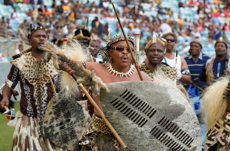 Zulu men sing and dance as they arrive for a coronation event. AP