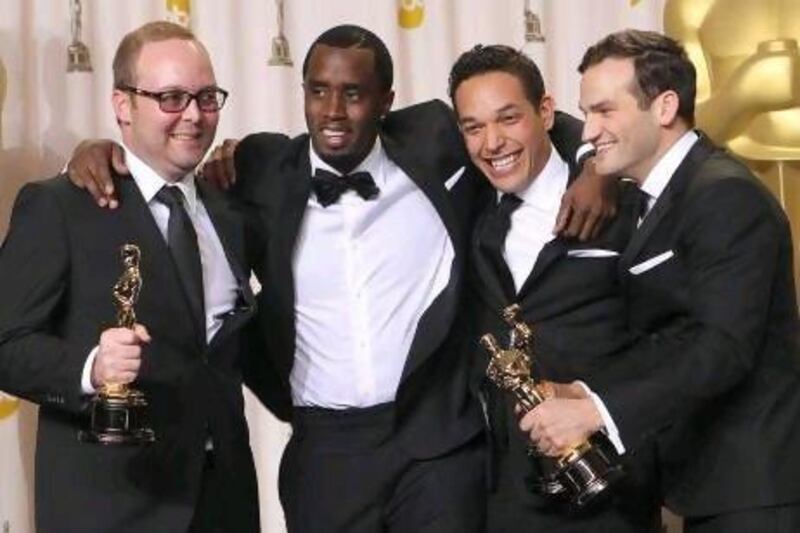 Rich Middlemas, left, TJ Martin, second from right, and Daniel Lindsay, right, pose with P Diddy with their Oscars for Undefeated. Joel Ryan / AP Photo