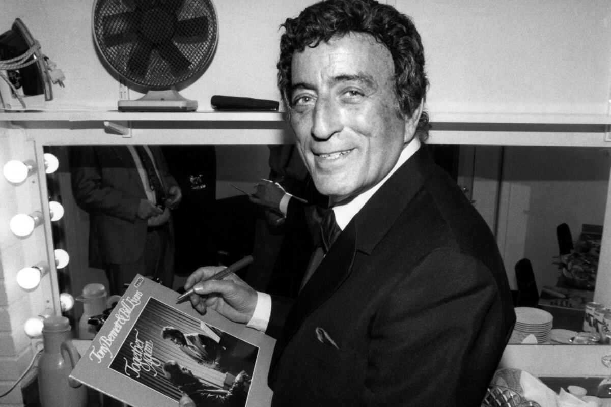 US singer Tony Bennett signs an autograph to a record in his loge on march 6, 1988 after the concert at the Stockholm "B�rsen". (Photo by Bernt CLAESSON / PRESSENS BILD / AFP)