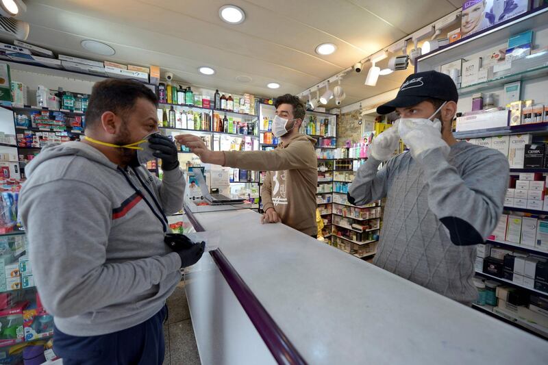 An Iraqi man checks a protective mask at a pharmacy in the holy Iraqi city of Najaf. AFP