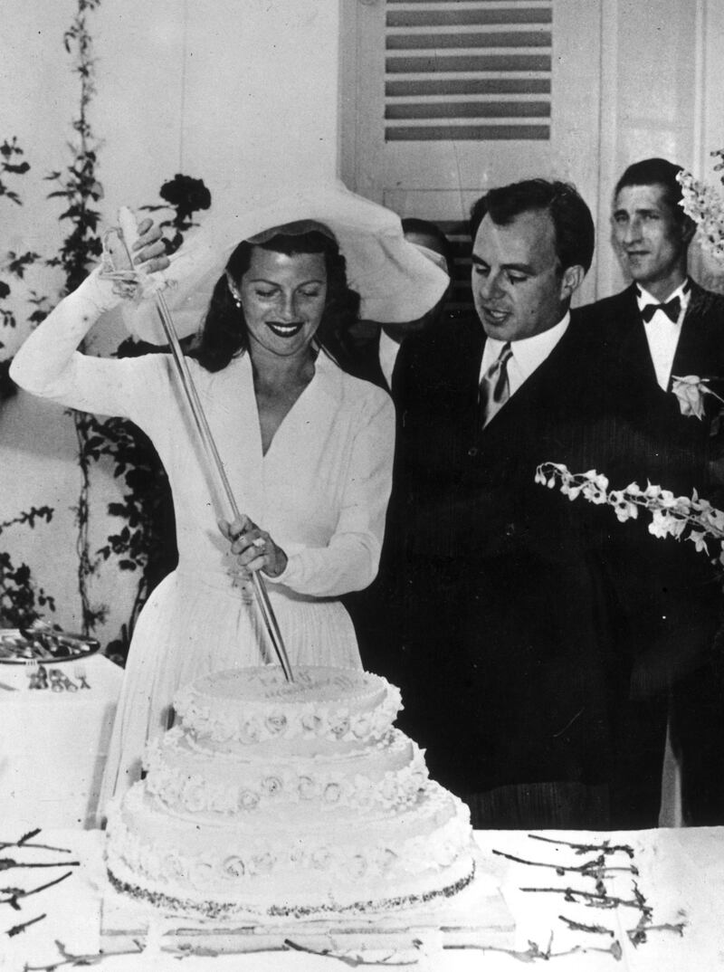 27th May 1949:  American actress Rita Hayworth (1918 - 1987) with her husband, the Prince Aly Khan, cutting the cake on their wedding day.  (Photo by Keystone/Getty Images)