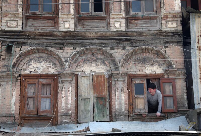 A Kashmiri man looks from a window of his home in Srinagar in August. EPA