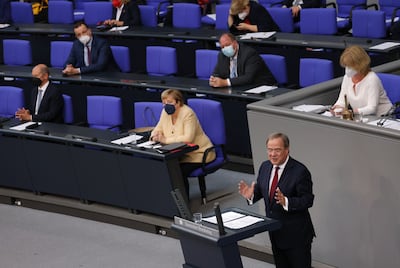 Mrs Merkel looks on as her centre-right party's nominee Armin Laschet speaks to parliamentarians in Berlin. Getty 