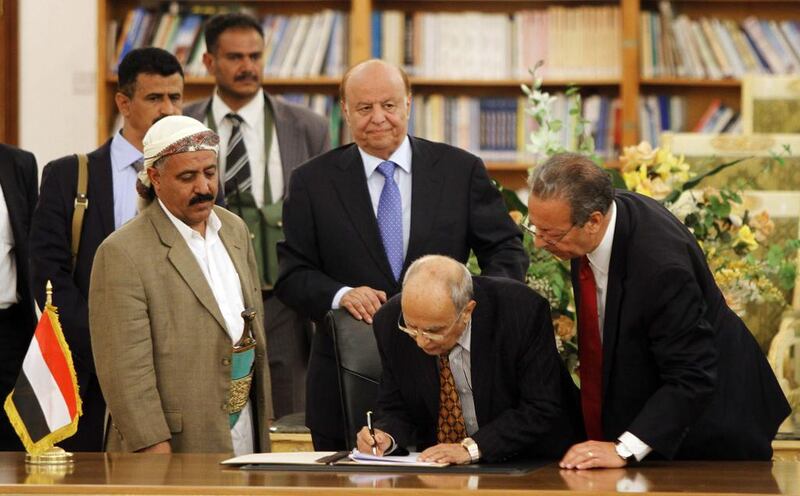 Abd Al Karim Al Iryani (centre, bending) advisor to Yemeni president Abd Rabbu Mansour Hadi (centre, in blue tie) signs the ceasefire agreement to end days of street violence, in the presence of UN special envoy Jamal Benomar (right) in Sanaa September 21, 2014. Yemen's Shiite rebels are calling for a more inclusive government. Mohamed Al Sayaghi/Reuters