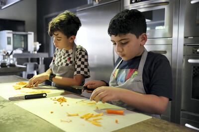 DUBAI, UNITED ARAB EMIRATES , March 5  – 2020 :-  Left to Right - Ismaiel and Yazan chopping vegetables during the cooking class at the Top Chef Dubai cooking school on Jumeirah Beach Road in Dubai. (Pawan Singh / The National) For Lifestyle. Story by Janice Rodrigues