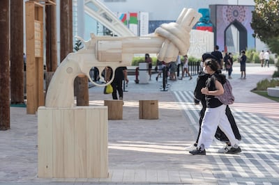 A wooden sculpture of a gun with a knot tied in its barrel at the Sweden Pavilion at Expo 2020. The sculpture, Non-Violence, is also known as 'The Knotted Gun' and was originally created by a Swedish artist Carl Fredrik Reuterswärd. Antonie Robertson / The National

