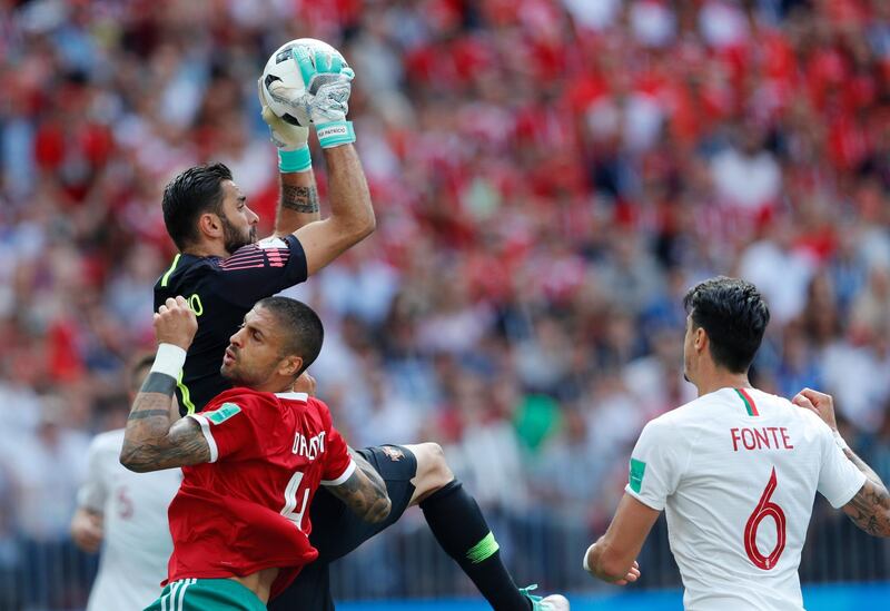 Portugal goalkeeper Rui Patricio makes a save ahead of Morocco's Manuel Da Costa as Portugal's Jose Fonte, right, looks on. Hassan Ammar / AP Photo