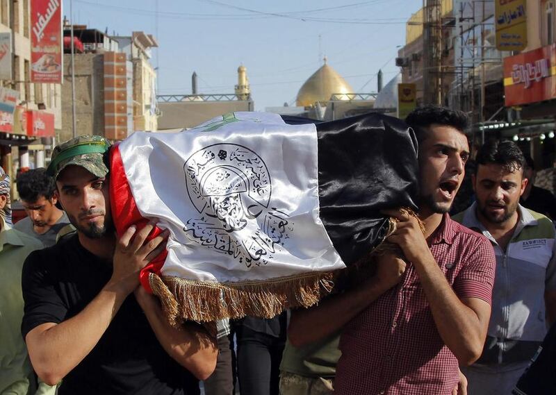 Mourners carry the flag-draped coffin of Abdullah Swadi, a member of an Iraqi volunteer forces group who was killed during clashes with Islamic militants, his family said, during his funeral procession in the Shiite holy city of Najaf on July 8, 2014. Jaber Al Helo / AP
