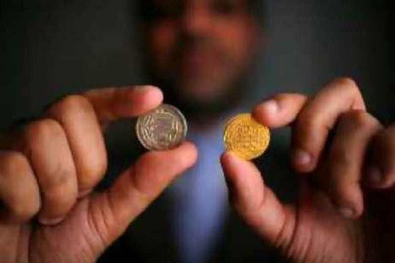 Abu Dhabi - June 26, 2008. Dr. Farhat Hussain, Specialist historian, archaeologist, sociologist, educationalist, explorer, holds a silver dirhem coin (left) from the 770's AD found in Scandinavia and a gold dinar coin from the 920's AD found in Russia, both produced in Baghdad. ( Philip Cheung / The National ) *** Local Caption ***  PC0072-DrFarhatHussain.jpgPC0072-DrFarhatHussain.jpg